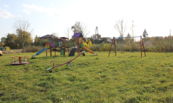 Na zdjęciu zobrazowano plac zabaw, widoczne są huśtawki oraz zjeżdżalnie