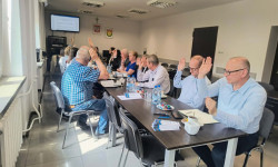 Na zdjęciu przy stole w sali konferencyjnej widać głosujących członków stowarzyszenia