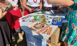 Osoby przy stoliku oglądają foldery promocyjne 